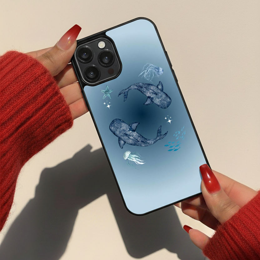 Phone case with whale design held by hands wearing red sleeves